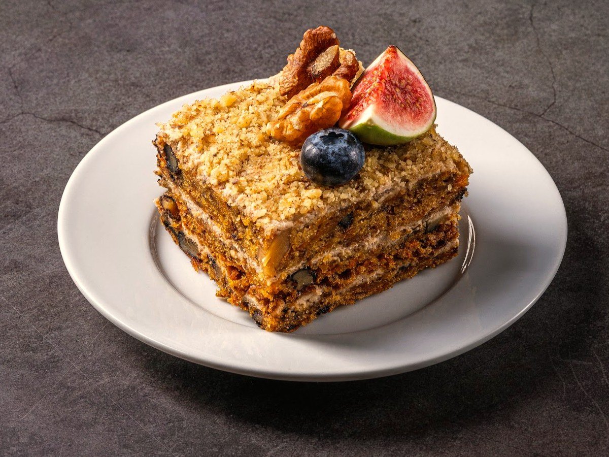 Slice of carrot cake with walnuts, fig and blueberry